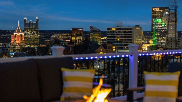 A city skyline at dusk with a fire feature in the foreground. - Mt. Washington Marvel. Stunning New Design, Epic Views, Hot Tub, Parking (Pittsburgh)