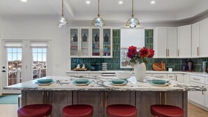 A modern kitchen with a large island, bar stools, and pendant lighting. - Mt. Washington Marvel. Stunning New Design, Epic Views, Hot Tub, Parking (Pittsburgh)