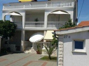 A two-story building with a balcony, a small garden area, and a visible door number. - Villa Ivan Vodice -Studio Apartment with Balcony 3 (Vodice)