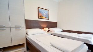 A hotel room with a bed, a bedside table, a lamp, and a painting on the wall.