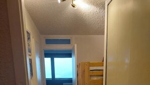 A narrow hallway with a bunk bed, a wardrobe, and a window with a view. - 300m from ski slopes, 7th floor, balcony, tv, ski locker, 32m², Pra Loup (Pra Loup)