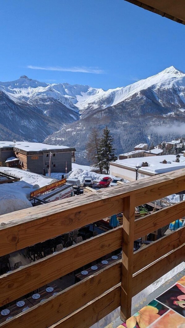 A mountain view with a wooden balcony, a restaurant, and a snow-covered landscape. - 200m from resort center, 3rd floor, balcony, tv, 27m², Orcières Merlette 1850 (Orcières)