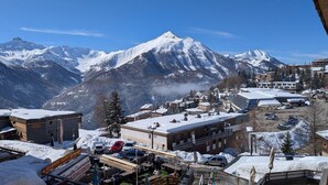 Un pueblo cubierto de nieve con edificios, un restaurante y automóviles estacionados.