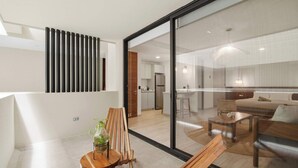 A modern interior with a dining area, kitchen, and a glass partition. - Rooftop Pool & Gym walkable studio full equipped (Playa del Carmen)