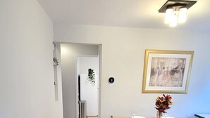 Un comedor con mesa de madera, sillas y un cuadro en la pared.