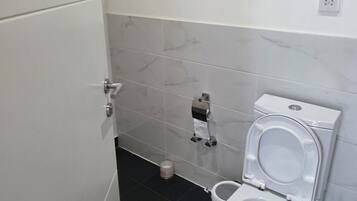 Een douche, handdoeken, zeep, toiletpapier
