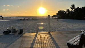 Un paseo marítimo con un banco, una puerta y vistas al océano.