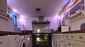Une petite cuisine équipée d’un lave-linge, d’un four à micro-ondes et d’une cuisinière.