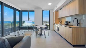 Una cocina moderna con armarios de madera, una mesa redonda para comer y vistas a la ciudad.