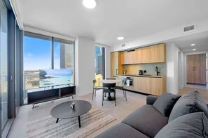 Un apartamento moderno con balcón, comedor, cocina y sala de estar.