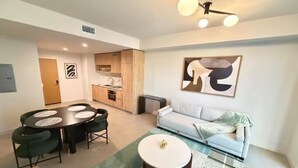 A modern living room with a dining area, a sofa, and a coffee table. - 2411 Brand New 1BR - Rooftop Pool, Coworking, Gym, Saun (Miami)