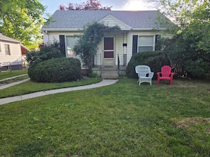 A house with a front porch, a pathway leading to the entrance, and two Adirondack chairs. - Comfortable 2 Bedroom Upper-Level Home in Sugarhouse (Salt Lake City)