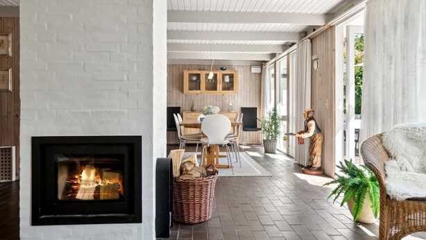 Un interior moderno con chimenea, comedor y armarios de cocina.