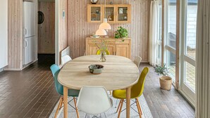 Un comedor con una mesa redonda, sillas, una lámpara y una planta.