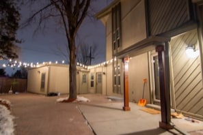 Ein Wohngebäude mit Garage, Baum und Lichterketten.
