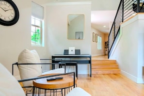 Un salon moderne comprenant un canapé, une table basse, un bureau et un escalier.