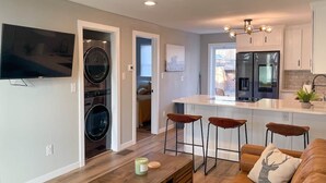 Een moderne keuken met een ingebouwde oven, een koelkast en een bar met krukken.