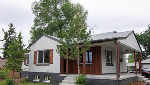 Ein modernes, zweistöckiges Haus mit Veranda, kleinem Vorgarten und Auffahrt.