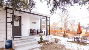 Ein Haus mit Veranda, Treppe, Tür und Briefkasten.