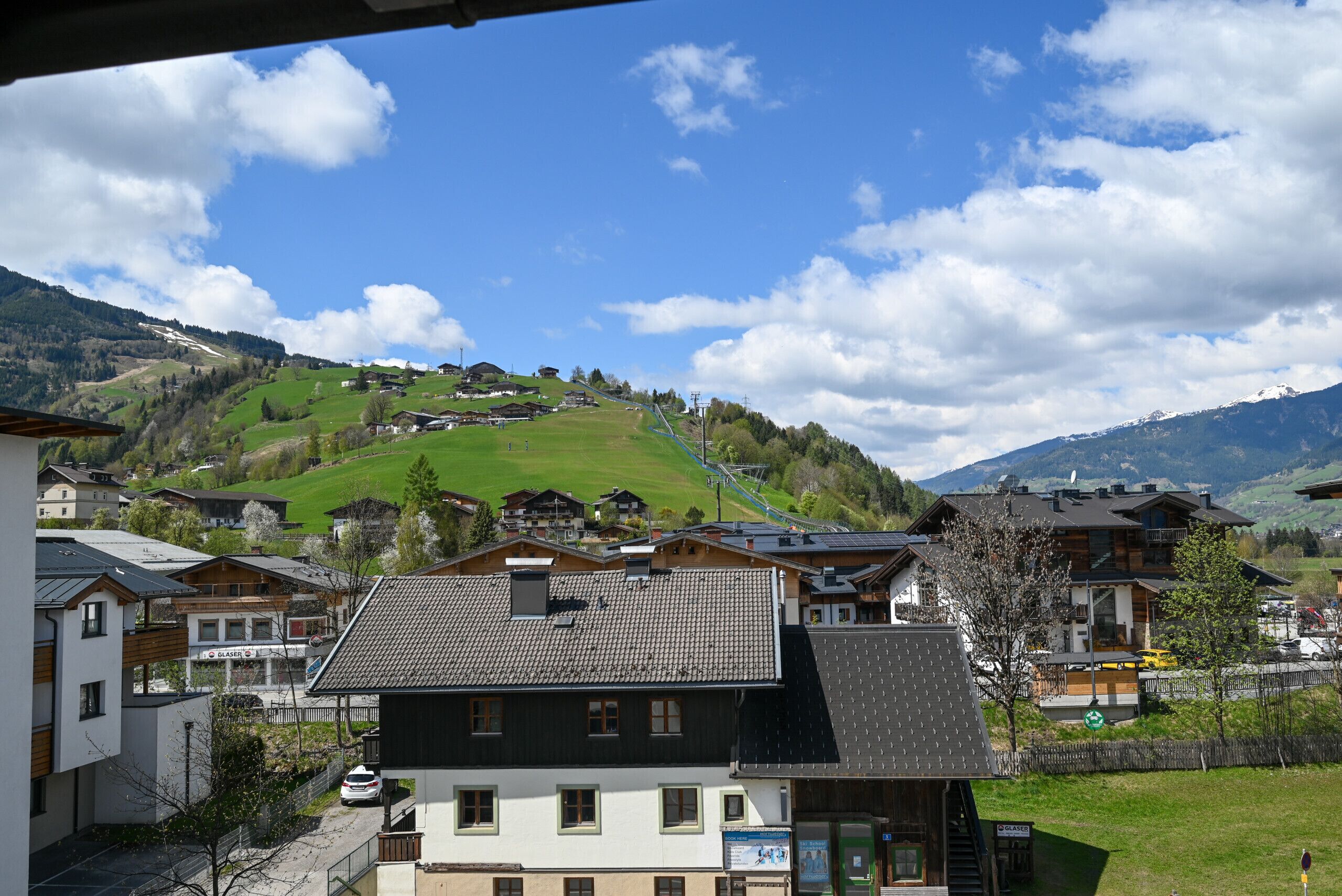 A residential area with houses, a ski slope, and a mountain in the background.