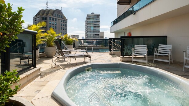 A rooftop pool area with lounge chairs, a hot tub, and potted plants. - Studio with Parking Space in the Heart of Itaim (São Paulo)