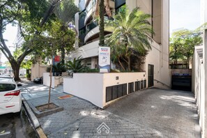 A modern building with a sign indicating a restaurant named 'KASTRO' and a parking area with a white car. - Cozy Studio Itaim Bibi (São Paulo)