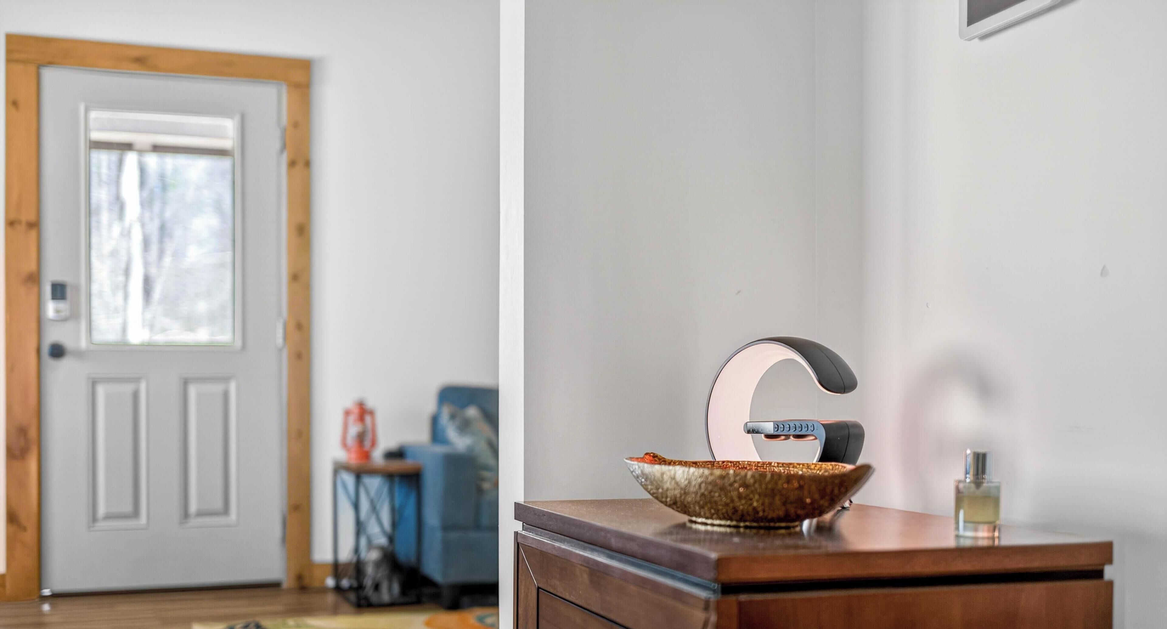 Un baño con tocador de madera, un lavabo con grifo moderno y un cuenco decorativo sobre la encimera.