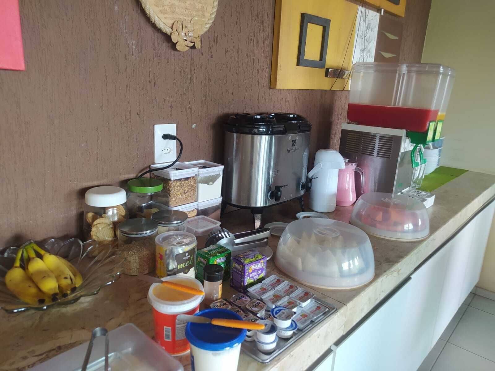 Una encimera de cocina con diversos alimentos, una cafetera y una licuadora.