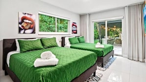 Ein Hotelzimmer mit zwei Betten, einem großen Fenster und Blick auf grüne Natur.