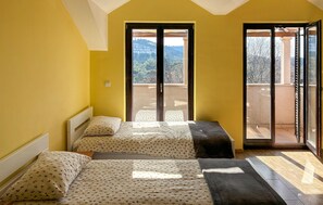 A bedroom with two beds, a balcony, and a view of the outdoors. - Cozy home in Donji Humac (Donji Humac)