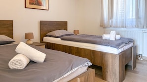 A bedroom with two beds, a wooden headboard, bedside lamps, a radiator, and a window with sheer curtains. - 2 bedroom gorgeous apartment in Donji Humac (Donji Humac)
