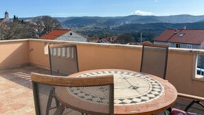 A round table with a mosaic top, two mesh chairs, and a view of a mountainous landscape. - 2 bedroom gorgeous apartment in Donji Humac (Donji Humac)