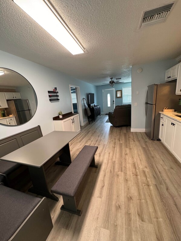 Une cuisine moderne avec un coin repas, un grand miroir et un ventilateur de plafond.