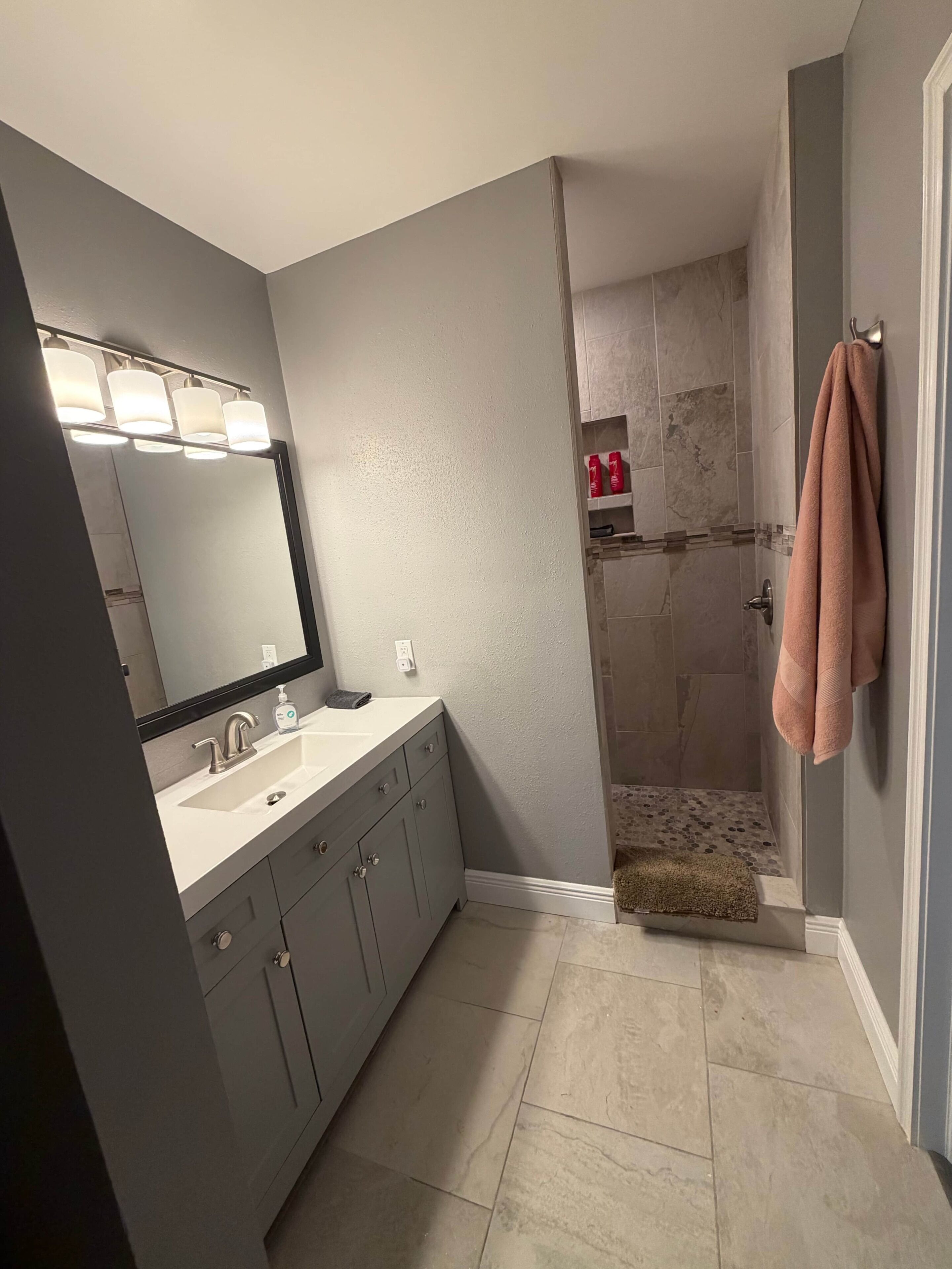 Un bagno con lavandino, specchio e doccia.