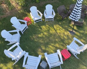 A circular arrangement of outdoor seating with chairs and a table, surrounded by grass. - Oasis in the Narragansett Pier. Family retreat home Comfortably sleeps 12 (Narragansett)