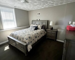 A bedroom with a bed, nightstands, a lamp, and a window with blinds. - Oasis in the Narragansett Pier. Family retreat home Comfortably sleeps 12 (Narragansett)
