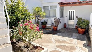 A courtyard with potted plants, a white building with a tiled roof, and a door marked with the number 07. - Servigueira by Grota Lodging (Leiria)