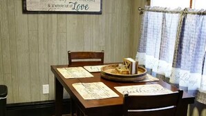 Une table à manger avec des menus, une bougie et une assiette décorative.