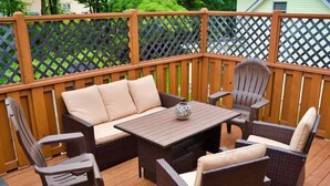 Une terrasse dotée de meubles en osier, d’une table et de chaises.