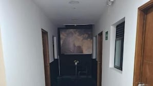 A hallway with a wooden floor, white walls, and a door on the right.