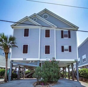 A two-story building with a gabled roof, multiple windows, and a covered porch area. - Beautiful 4-bedroom house with AC in lovely Murrells Inlet (Murrells Inlet)