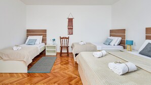 Ett hotellrum med två sängar, en stol, ett litet bord och en väggdekoration.
