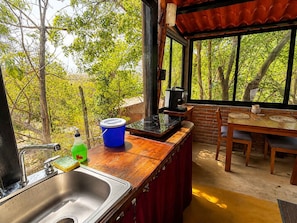 A kitchen with a sink, stove, and dining area with a table and chairs.