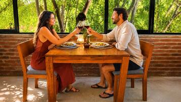 Une table en bois, deux chaises, une bougie et des assiettes remplies de nourriture.