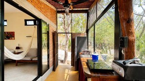 Una cocina moderna con cafetera espresso integrada, encimera de madera y vistas al exterior.