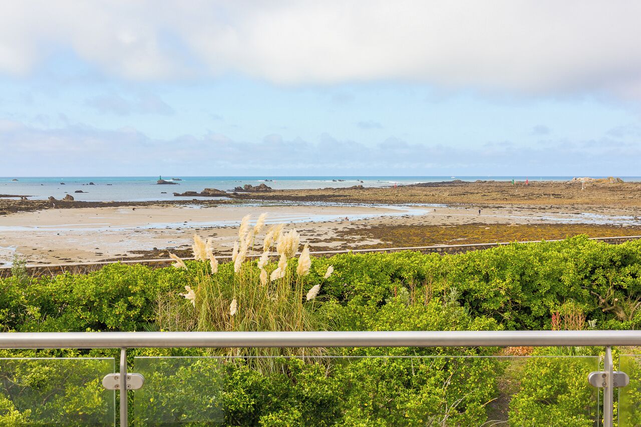 Et kystlandskab med strand, klippeformationer og vegetation.
