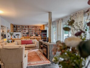 Un salon avec une cheminée, des étagères à livres, un canapé et une table basse.