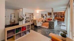 Un vaste espace de vie agrémenté d’une cheminée, d’une bibliothèque et d’un coin salon confortable.