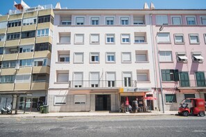 A multi-story building with a ground-level restaurant and a visible entrance. - HOUZE Four Bedroom Apartment near Lisbon Zoo (Lisboa)