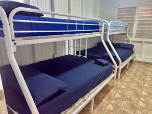A bunk bed room with white metal railings and blue bedding. - Large Group Townhouse w/ Pool Access & Pool Table (Cabo Rojo)